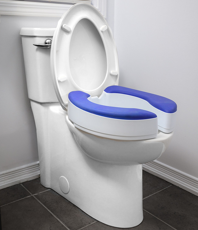 A raised toilet seat with blue padding and handles enhances bathroom safety.