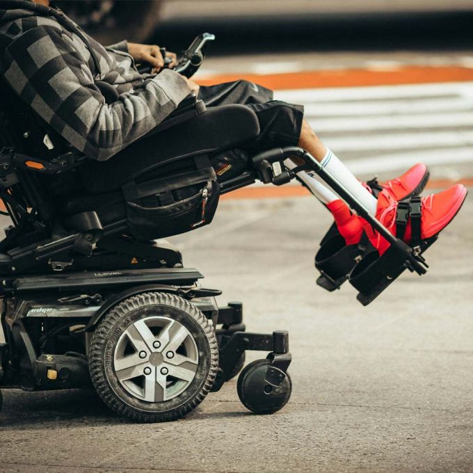 Using electric wheelchair on the street, showcasing mobility equipment from Core Medical Equipment